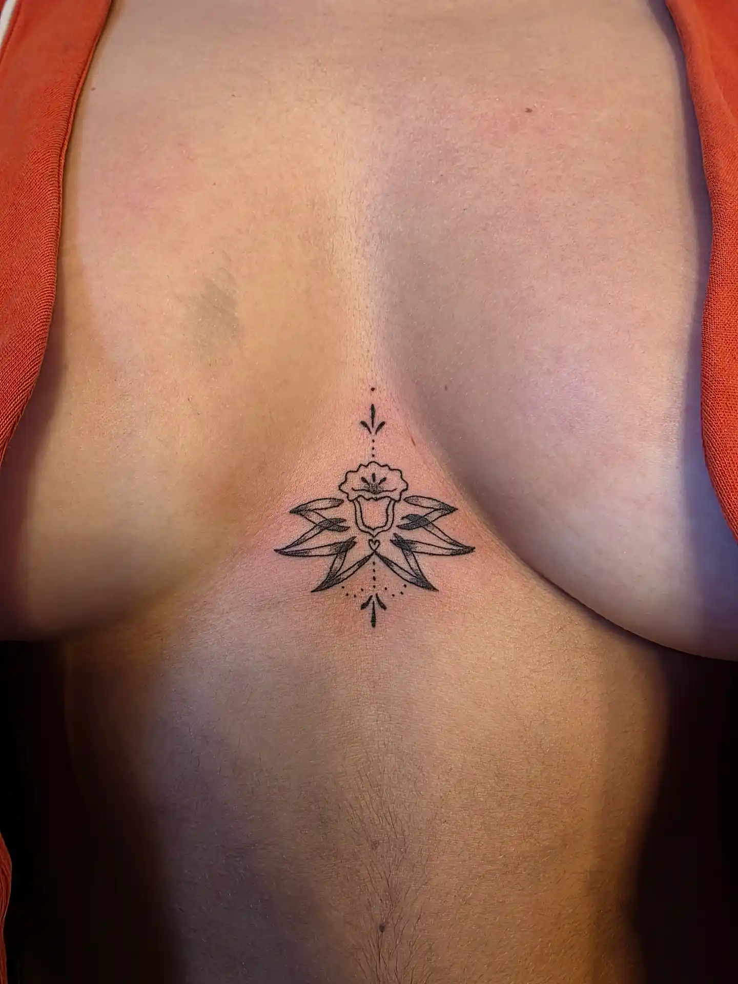 Tatouage lotus géométrique sous la poitrine - design symétrique fine line