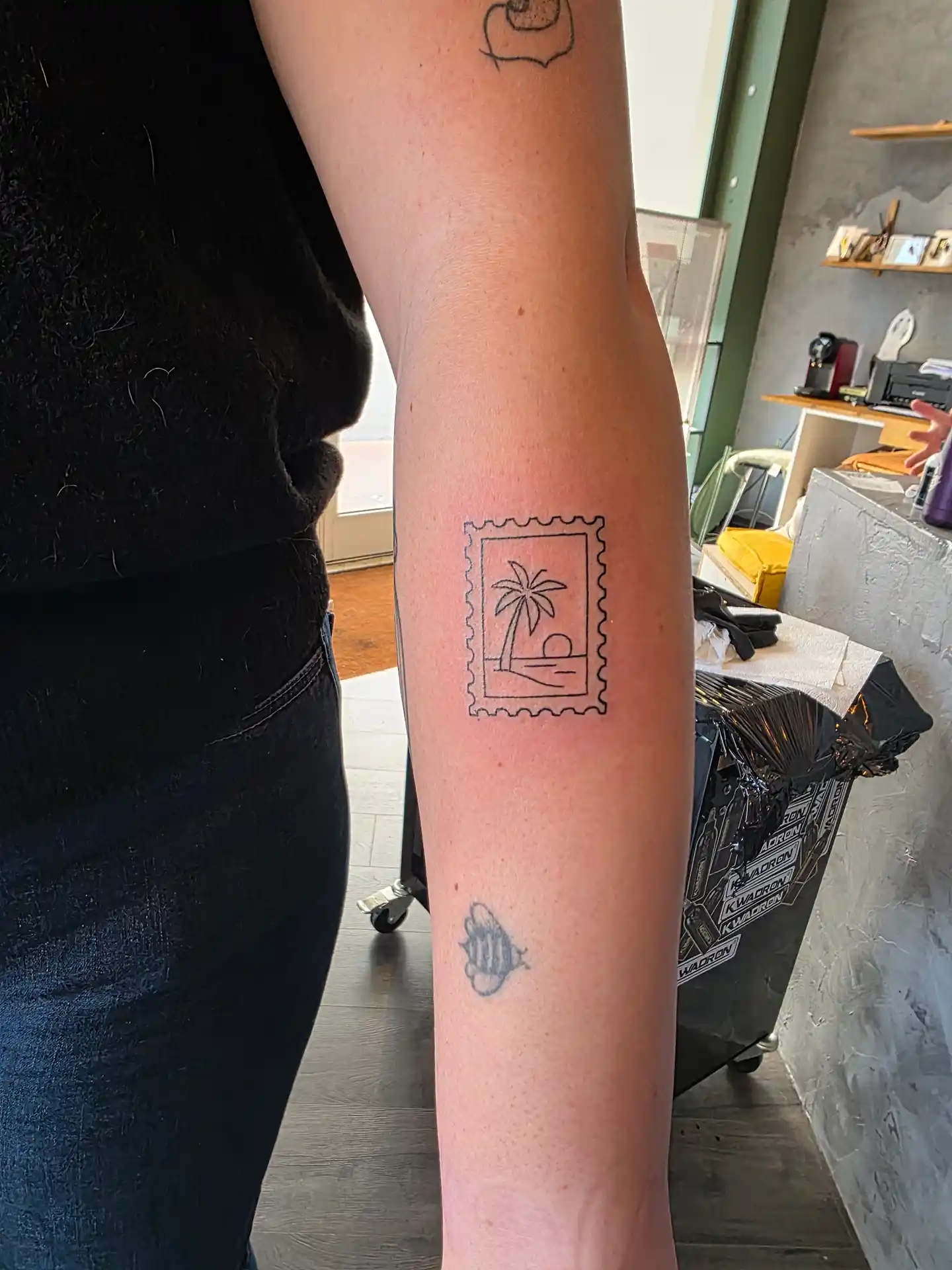 Tatouage timbre postal avec palmier - design ludique et voyageur